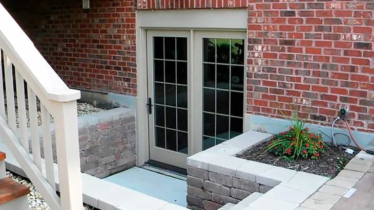 Basement renovation walk-out separate entrance to legal suite with French doors and brick facade in Toronto