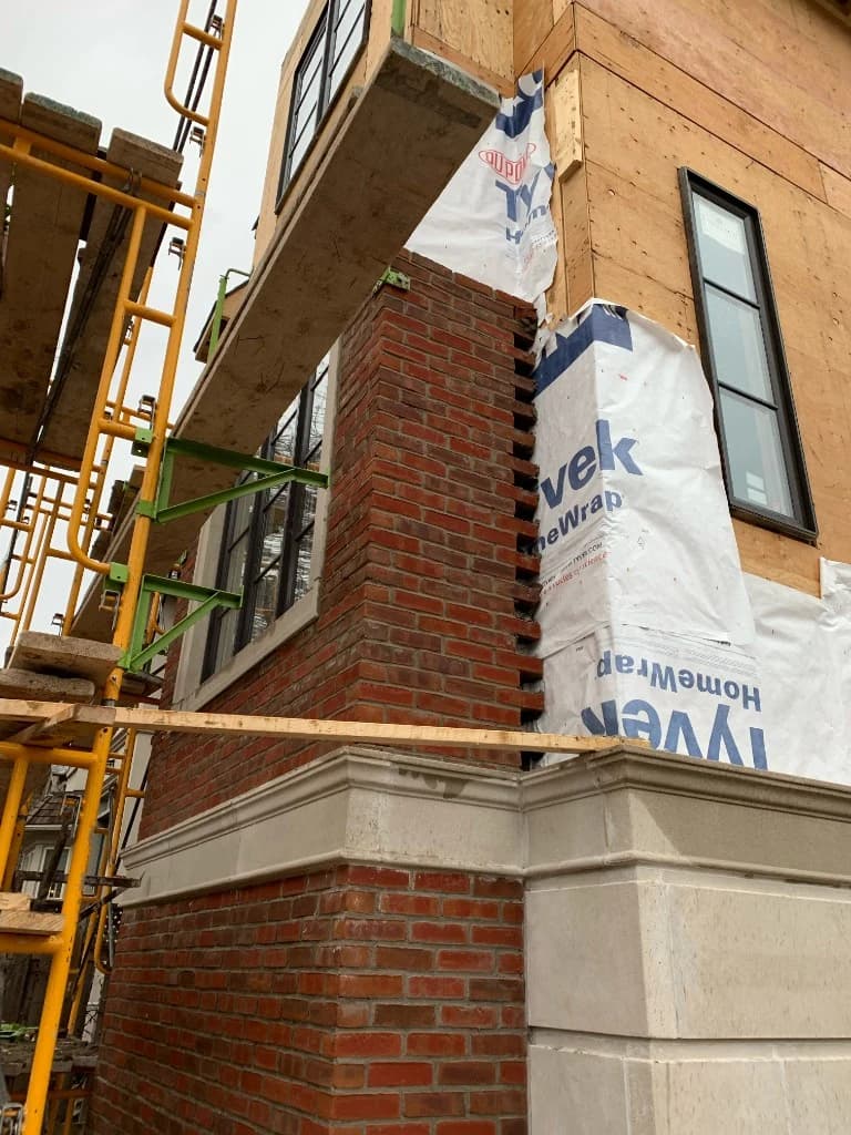 Custom build exterior brickwork and stone trim under construction in Toronto