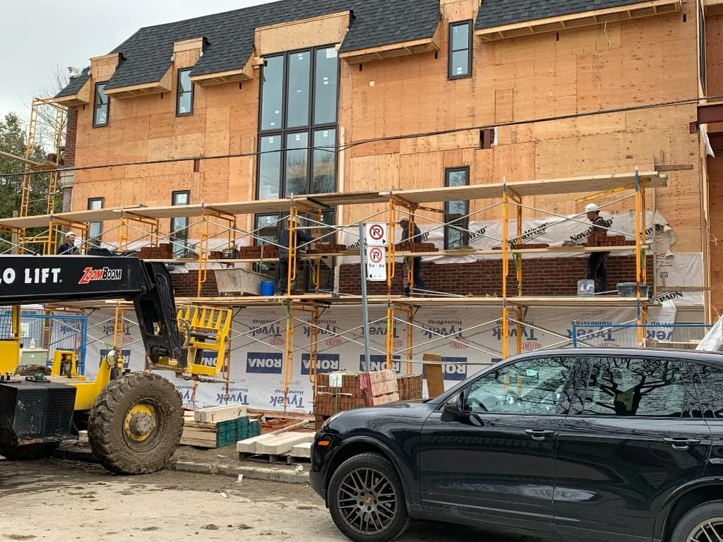 Custom home under construction with brick facade and scaffolding in Toronto