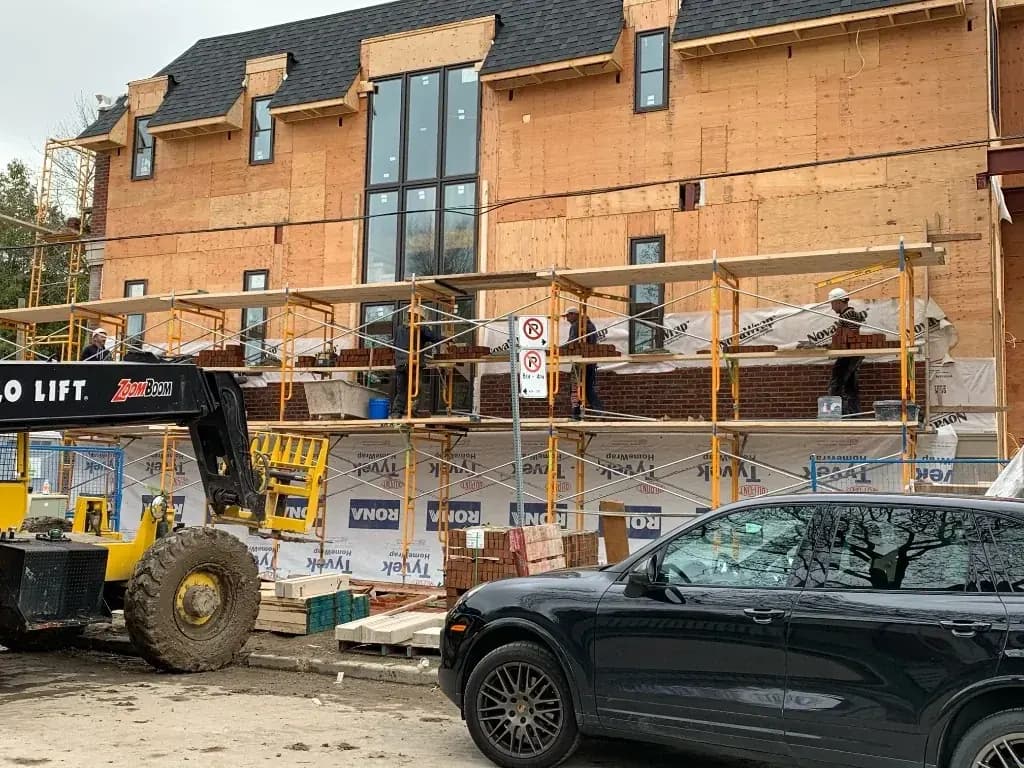 Custom home under construction with brick facade and scaffolding in Toronto
