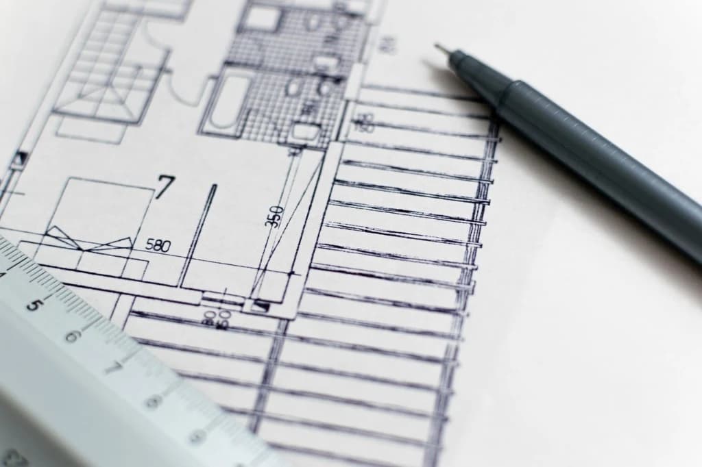 Detailed architectural blueprints with ruler and pen for custom home project planning and analysis in Toronto