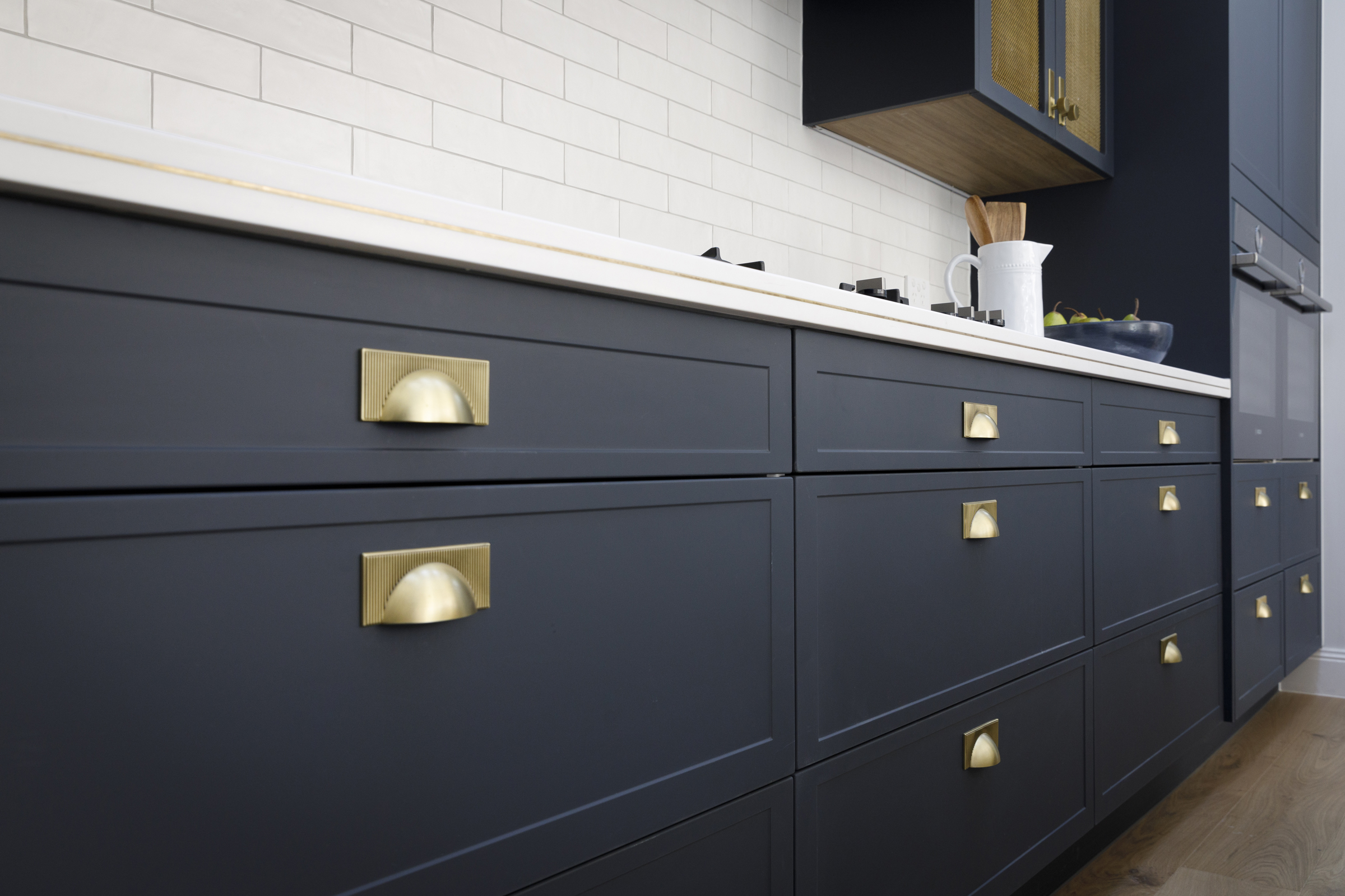 a kitchen with blue cabinets and white counter tops